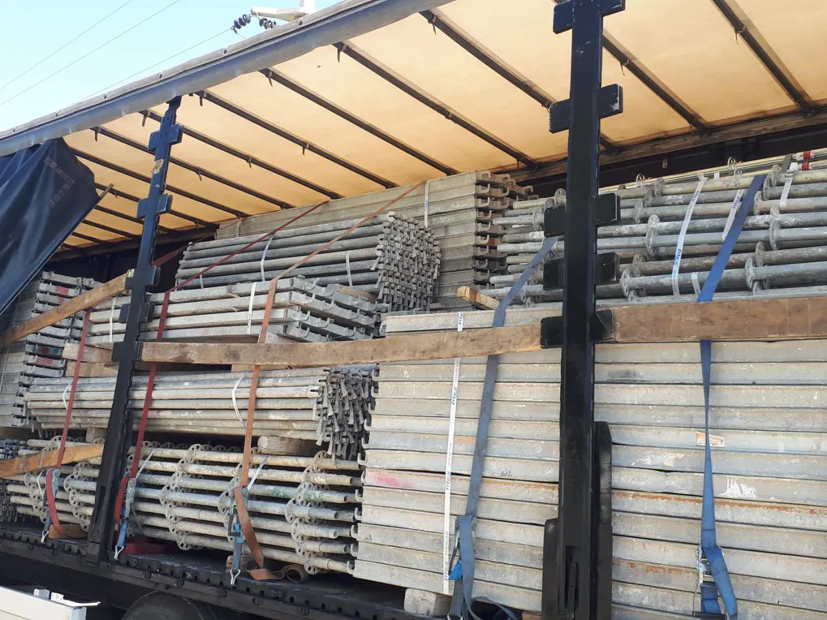 Tıra istiflenmiş ve kayışlanmış kullanılmış galvanizli iskele elemanları